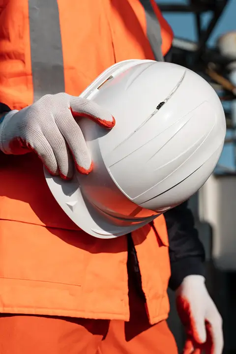 Obrero sujetando un casco de construcción